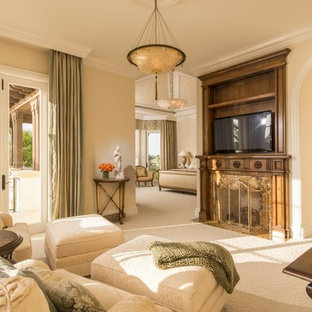 Inspiration for a medium sized mediterranean open plan living room in Miami with beige walls, carpet, a standard fireplace, a wooden fireplace surround and a wall mounted tv.