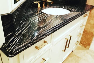 Example of a small master bathroom design in Miami with marble countertops and black countertops