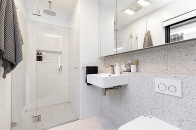 Small contemporary 3/4 bathroom in Sydney with a corner shower, white tile, ceramic tile, porcelain floors, a wall-mount sink, multi-coloured floor, a hinged shower door, a niche and a single vanity.