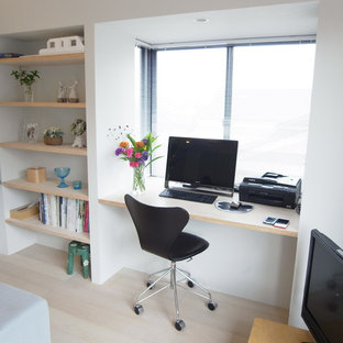 Design ideas for a modern study in Tokyo with white walls, plywood flooring, a built-in desk and beige floors.