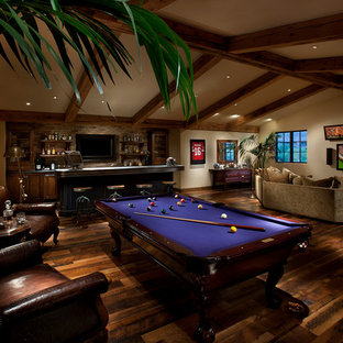 Großer Mediterraner Hobbyraum mit beiger Wandfarbe, Wand-TV und dunklem Holzboden in Phoenix