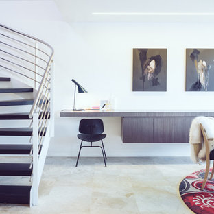 Bild på ett litet funkis hemmabibliotek, med vita väggar, kalkstensgolv och ett inbyggt skrivbord