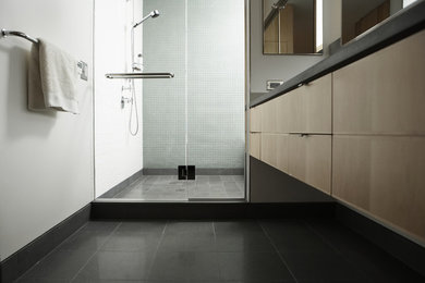 Example of a trendy alcove shower design in Orange County with flat-panel cabinets, white walls and solid surface countertops
