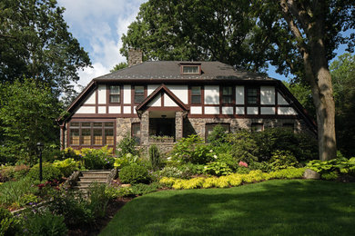 This is an example of a large traditional two-storey white exterior in New York with stone veneer.