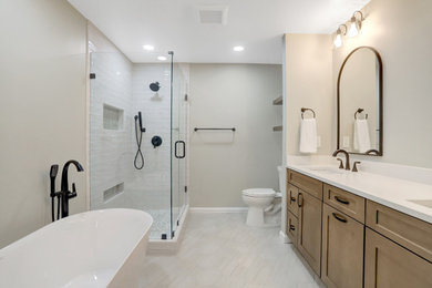 Bathroom - large master white tile and subway tile mosaic tile floor, beige floor and double-sink bathroom idea in DC Metro with shaker cabinets, medium tone wood cabinets, a two-piece toilet, gray walls, an undermount sink, quartz countertops, a hinged shower door, white countertops, a niche and a built-in vanity