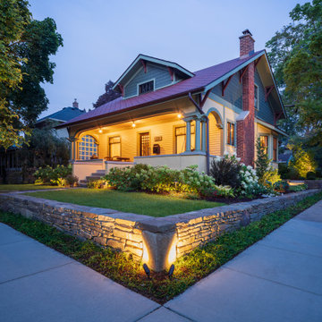 The front corner at dusk: stone walls, landing, and landscape lighting