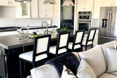 Example of a mid-sized porcelain tile kitchen design in Phoenix with a farmhouse sink, shaker cabinets, white cabinets, quartz countertops, white backsplash, ceramic backsplash, stainless steel appliances, an island and gray countertops
