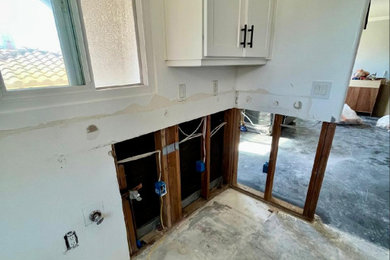 Eat-in kitchen - mid-sized modern u-shaped laminate floor eat-in kitchen idea in San Diego with an undermount sink, shaker cabinets, quartzite countertops, black backsplash, stone slab backsplash, stainless steel appliances and black countertops