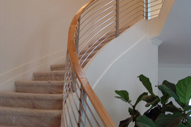 Foto de escalera curva grande con barandilla de metal