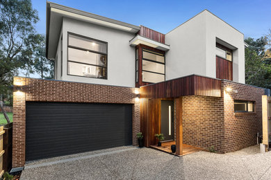 Photo of a modern two-storey concrete townhouse exterior in Melbourne with a flat roof.