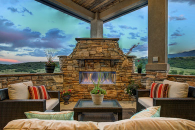Inspiration for a mid-sized arts and crafts backyard patio in Denver with a fire feature, tile and a roof extension.