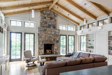 Inspiration for a mid-sized timeless open concept light wood floor family room remodel in Boston with white walls, a standard fireplace, a stone fireplace and no tv