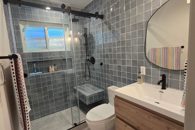 Example of a mid-sized minimalist master blue tile and porcelain tile single-sink, porcelain tile and gray floor bathroom design in Los Angeles with light wood cabinets, a one-piece toilet, an integrated sink, quartzite countertops, white countertops, a floating vanity and gray walls