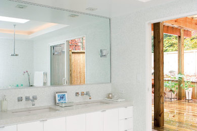 Mid-sized trendy master gray tile, white tile and mosaic tile linoleum floor and gray floor drop-in bathtub photo in Philadelphia with flat-panel cabinets, white cabinets, a one-piece toilet, gray walls, an undermount sink and laminate countertops