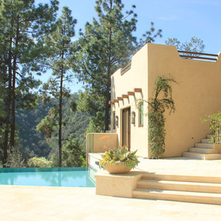 Großer Mediterraner Infinity-Pool neben dem Haus in individueller Form mit Poolhaus und Natursteinplatten in Los Angeles