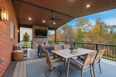Inspiration for a mid-sized transitional backyard second story mixed material railing deck remodel in Other with a fireplace and a roof extension