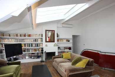 Idées déco pour un grand salon classique ouvert avec une bibliothèque ou un coin lecture, un mur blanc, un sol en bois brun, une cheminée standard, un manteau de cheminée en pierre, un téléviseur indépendant et un sol marron.