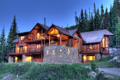 Large rustic three-story exterior home idea in Other
