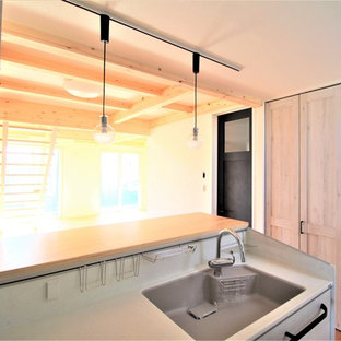 Idées déco pour une petite arrière-cuisine linéaire industrielle avec un évier 1 bac, un placard à porte plane, des portes de placard grises, un plan de travail en surface solide, une crédence blanche, une crédence en ardoise, un électroménager en acier inoxydable, un sol en linoléum, aucun îlot, un sol gris et un plan de travail gris.