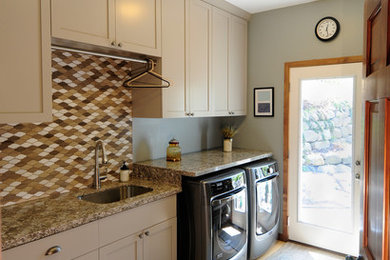 Inspiration for a mid-sized single-wall light wood floor utility room remodel in Minneapolis with an undermount sink, shaker cabinets, gray cabinets, granite countertops, blue walls and a stacked washer/dryer