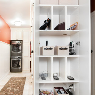 Photo of a small traditional utility room in Chicago with white cabinets, laminate countertops, orange walls, ceramic flooring, a stacked washer and dryer and raised-panel cabinets.