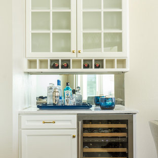 オーランドの中サイズのトラディショナルスタイルのおしゃれなホームバー (落し込みパネル扉のキャビネット、白いキャビネット、クオーツストーンカウンター、白いキッチンパネル、無垢フローリング、茶色い床、シンクなし、ミラータイルのキッチンパネル) の写真