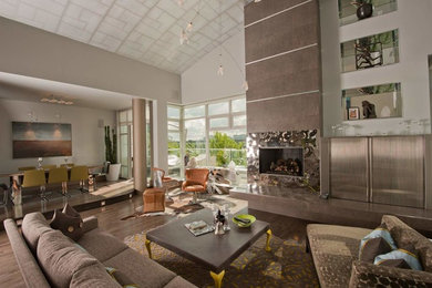 Example of a huge trendy open concept medium tone wood floor living room design in Vancouver with beige walls, a standard fireplace, a tile fireplace and a concealed tv