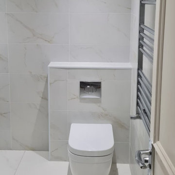 Bathroom rebuild. White toilet and white tiles. Wall heater.