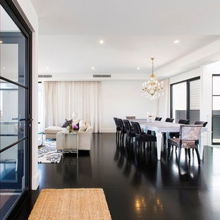 ニューカッスルの広いモダンスタイルのLDKの画像 (白い壁、塗装フローリング、標準型暖炉、石材の暖炉まわり、黒い床)