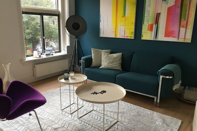 Inspiration for a mid-sized modern open concept medium tone wood floor and brown floor living room remodel in Amsterdam with green walls, no fireplace, a metal fireplace and a tv stand