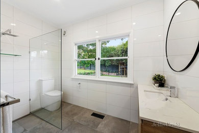 Design ideas for a mid-sized contemporary 3/4 bathroom in Melbourne with raised-panel cabinets, white cabinets, an open shower, a two-piece toilet, white tile, porcelain tile, white walls, porcelain floors, an integrated sink, marble benchtops, beige floor, an open shower and white benchtops.