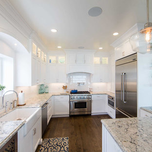 Mid-sized beach style kitchen pantry appliance - Kitchen pantry - mid-sized beach style galley medium tone wood floor and brown floor kitchen pantry idea in San Luis Obispo with a farmhouse sink, beaded inset cabinets, white cabinets, marble countertops, white backsplash, ceramic backsplash, stainless steel appliances and an island