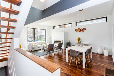 Mid-sized contemporary open plan dining in Toronto with white walls, medium hardwood floors, a ribbon fireplace and a metal fireplace surround.