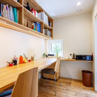 他の地域のモダンスタイルのおしゃれなホームオフィス・仕事部屋 (白い壁、無垢フローリング、造り付け机、茶色い床) の写真