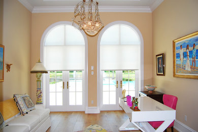 Inspiration for a mid-sized timeless freestanding desk light wood floor study room remodel in Miami with orange walls