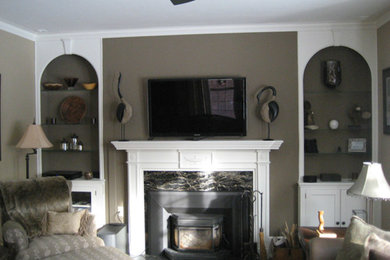 Inspiration for a mid-sized light wood floor living room remodel in Milwaukee with beige walls, a standard fireplace, a stone fireplace and a wall-mounted tv