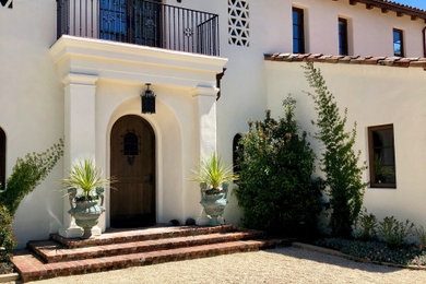 Photo of a large mediterranean front door in San Francisco with white walls, a single front door and a dark wood front door.