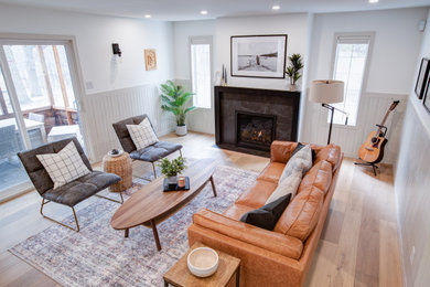 Photo of a medium sized contemporary living room in Other with white walls, vinyl flooring, a tiled fireplace surround, a wall mounted tv and brown floors.
