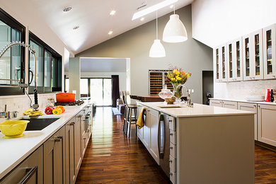 Large transitional u-shaped dark wood floor and brown floor eat-in kitchen photo in San Francisco with an undermount sink, shaker cabinets, white cabinets, quartzite countertops, gray backsplash, stainless steel appliances and an island