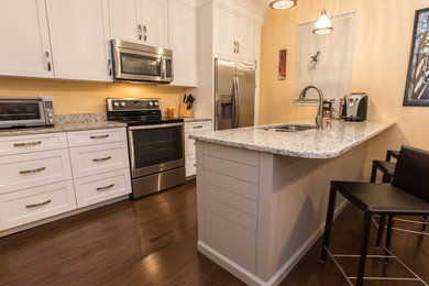 Mid-sized minimalist galley dark wood floor enclosed kitchen photo in Charleston with a double-bowl sink, shaker cabinets, white cabinets, granite countertops, stainless steel appliances and a peninsula