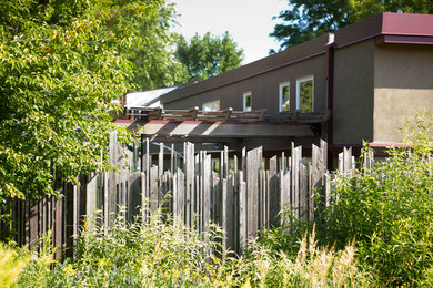 Mid-sized urban backyard patio photo in Minneapolis with a roof extension