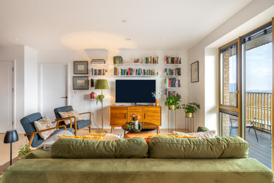 Imagen de salón abierto vintage de tamaño medio sin chimenea con paredes blancas, suelo de madera clara y televisor independiente