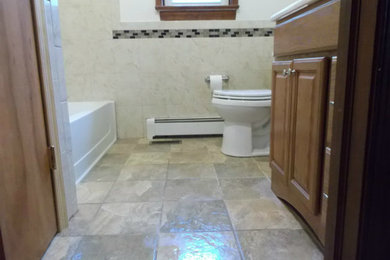 Example of a small beige tile bathroom design in Philadelphia with medium tone wood cabinets