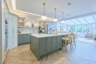 Large open plan kitchen in Other with green cabinets, quartz worktops, white splashback, an island, beige floors and white worktops.