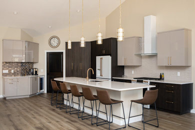 Large transitional vinyl floor and brown floor open concept kitchen photo in Other with an undermount sink, flat-panel cabinets, gray cabinets, quartz countertops, gray backsplash, ceramic backsplash, white appliances, an island and white countertops