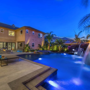 オレンジカウンティの大きいオーダーメイドトロピカルスタイルのおしゃれなプール (噴水、コンクリート敷き ) の写真