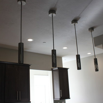 After: Open-plan kitchen with new pendant light fixtures over new breakfast bar