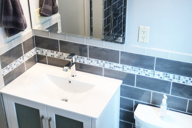 Small modern family bathroom in DC Metro with glass-front cabinets, white cabinets, an alcove bath, a shower/bath combination, a two-piece toilet, grey tiles, ceramic tiles, grey walls, porcelain flooring, a submerged sink, marble worktops, beige floors, a shower curtain and white worktops.