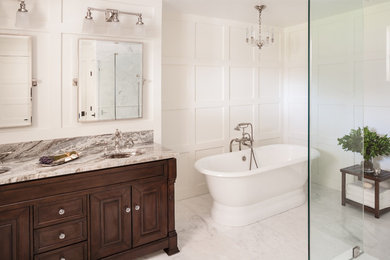 Large transitional master bathroom in New York with a freestanding tub, a curbless shower, a one-piece toilet, stone tile, beige walls, marble floors and an undermount sink.