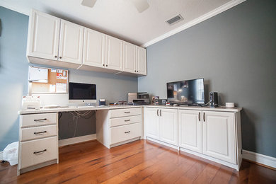 Photo of a large traditional home office in Orlando with grey walls, medium hardwood floors, no fireplace, a built-in desk and brown floor.